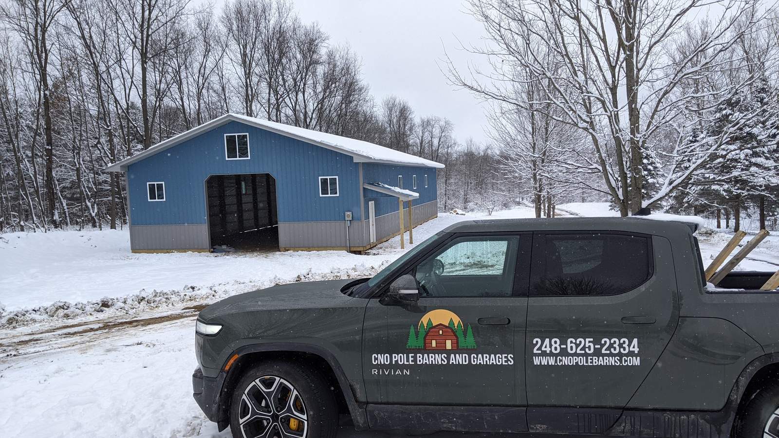 CNO truck parked in front of a finished blue pole barn in the snow