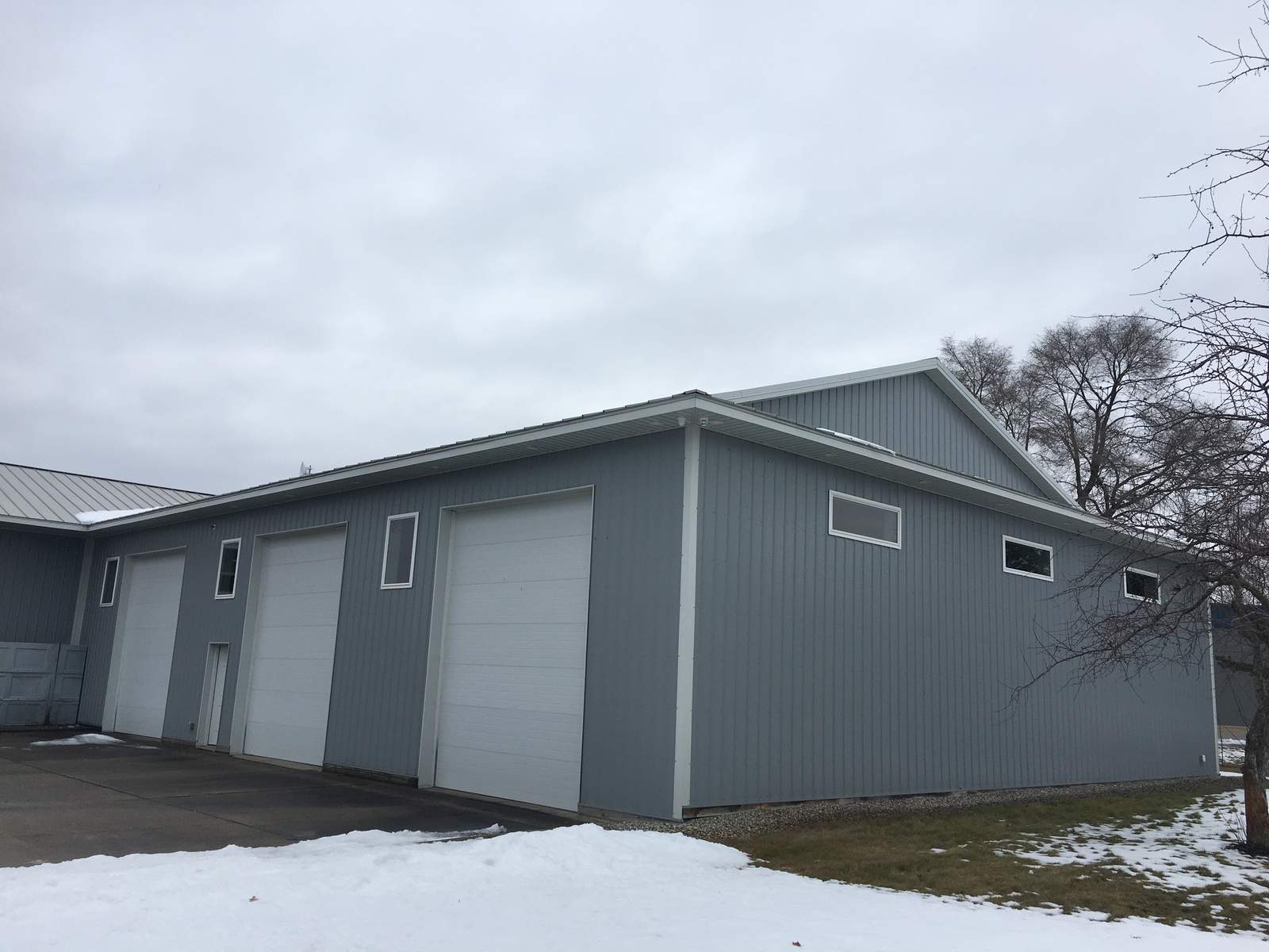 Gray multi-bay detached garage with three overhead doors