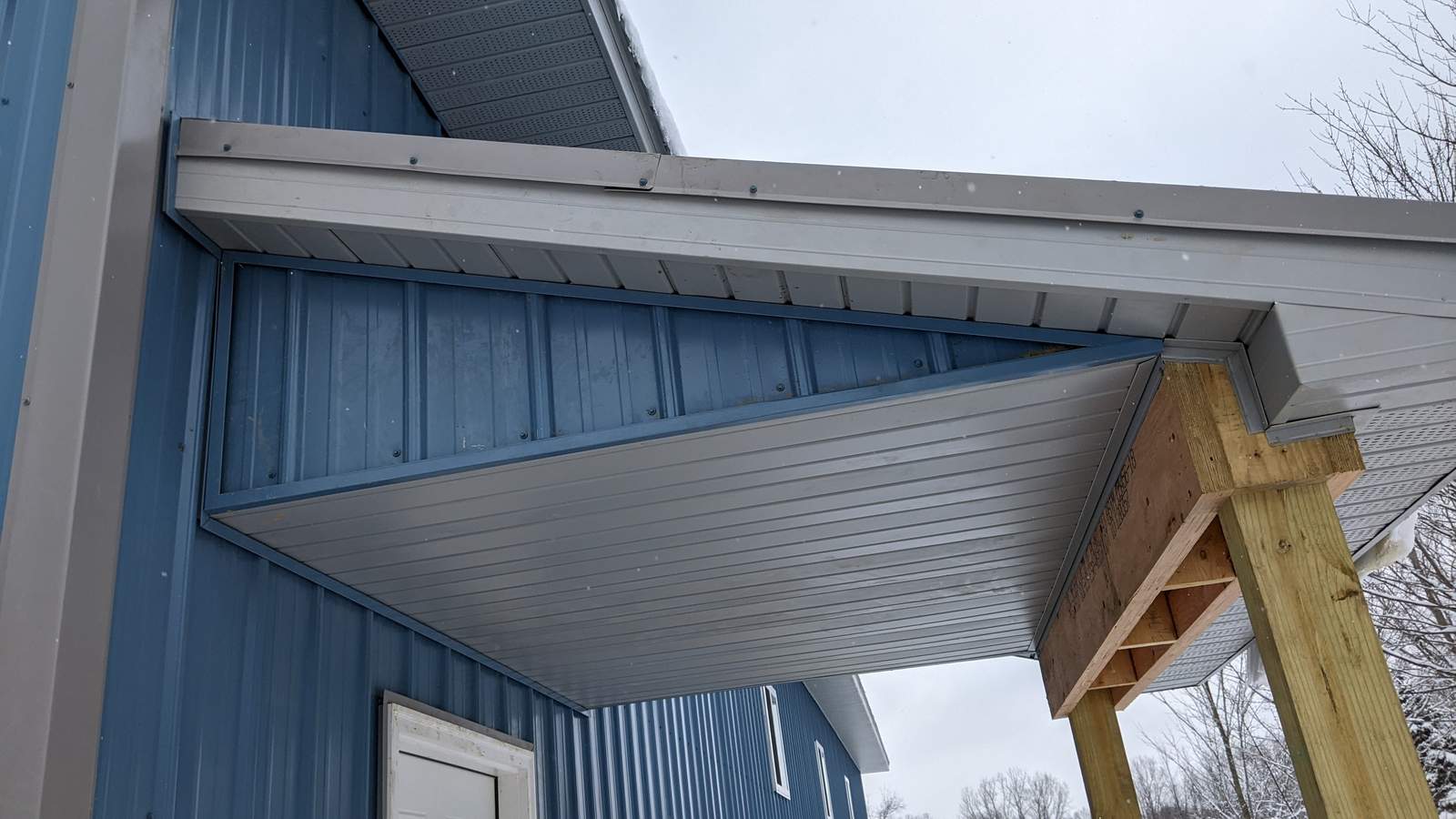 Close-up of eave and overhang trim detail on a blue pole barn