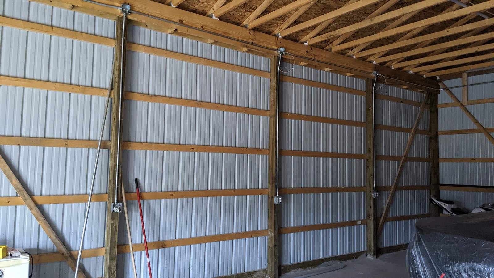 Interior of a pole barn showing framed stud walls with radiant barrier insulation