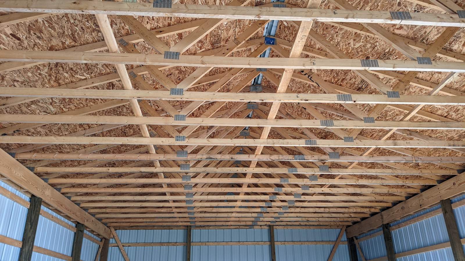 Interior view of pole barn roof trusses with radiant barrier insulation